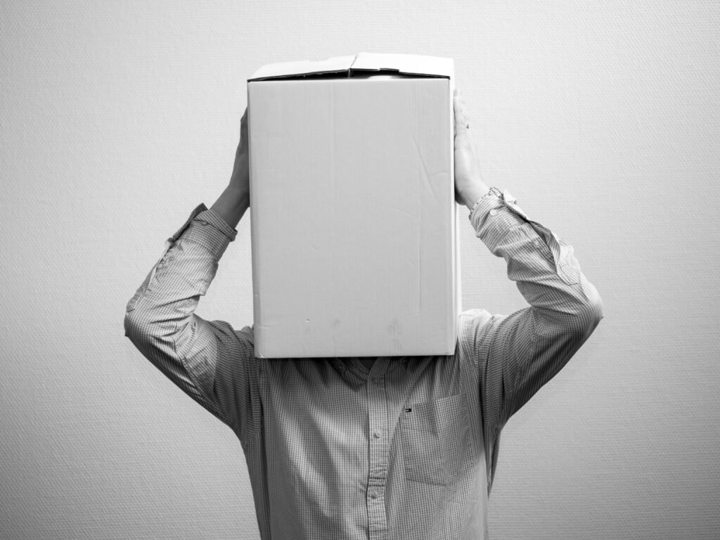 A person which puts a box on his head.