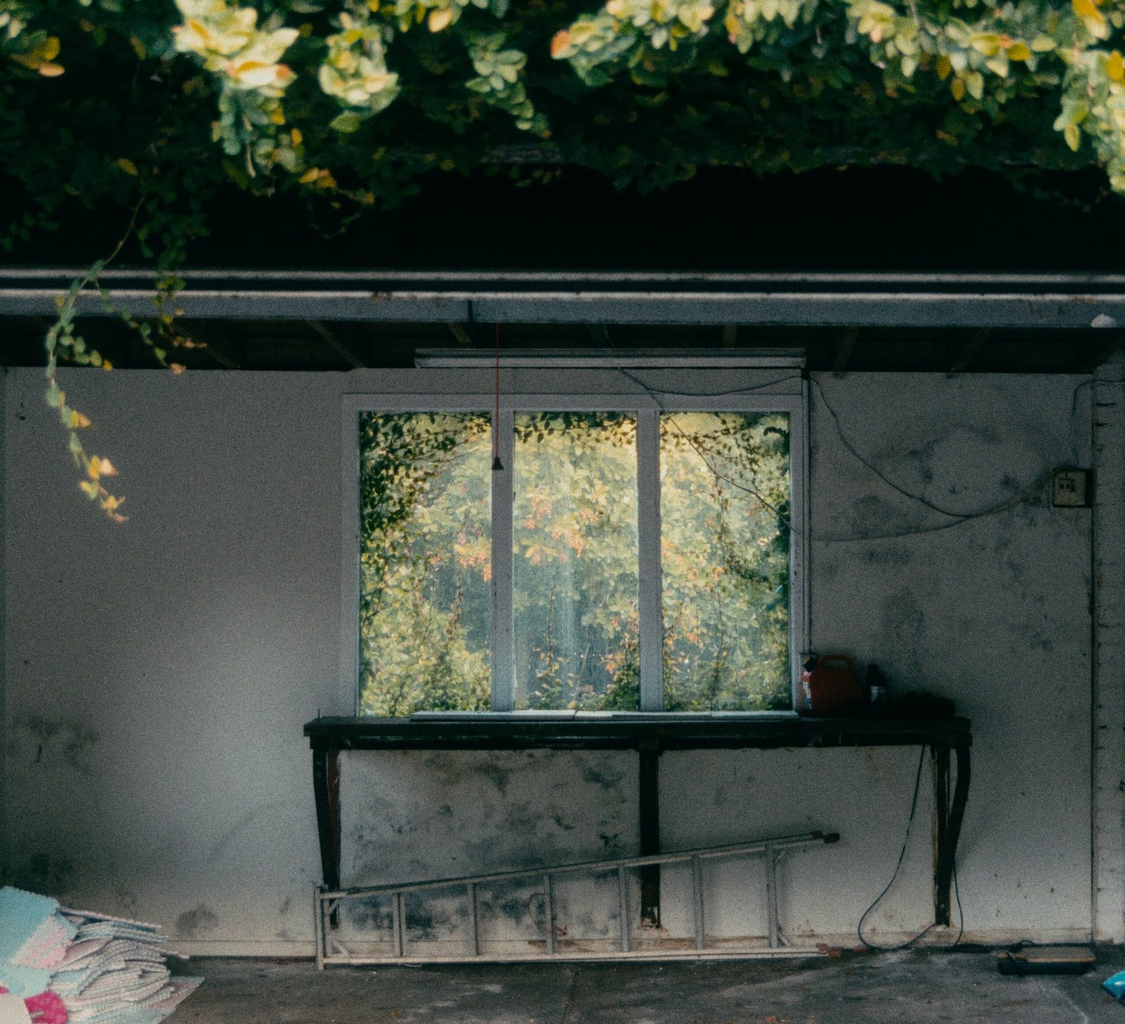 an old dusty room and a ruined window with a rotten wooden desk. 